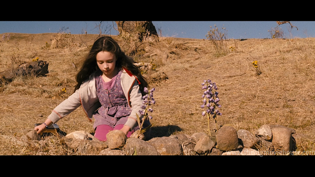 little girl has nothing better to do than play with rocks