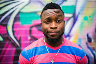 Man standing in front of a colorful outdoor wall mural