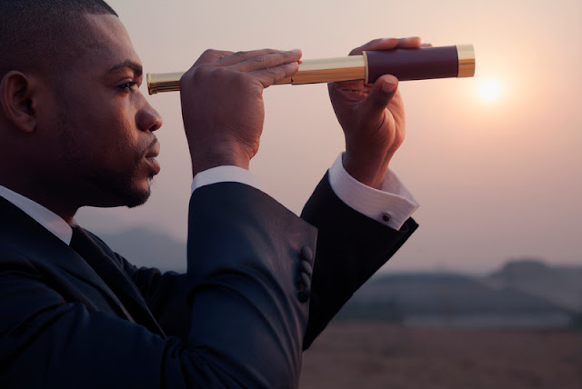  A man looking out at the horizon with a telescope