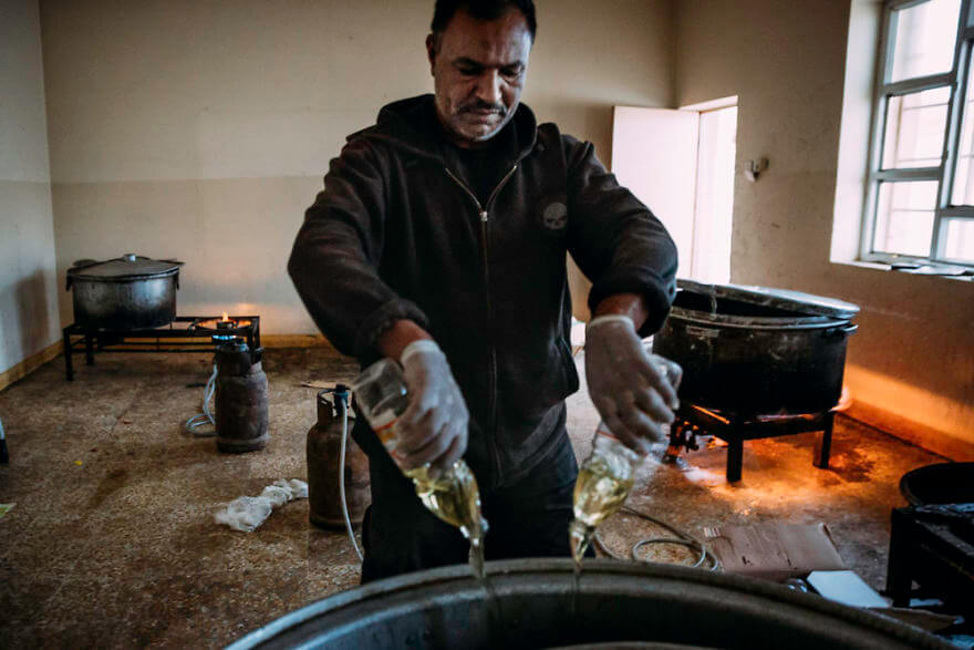Powerful Heart-Breaking Pictures Of The Battle Of Mosul - A cook prepares large amounts of rice for the soldiers