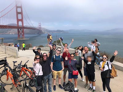 a big group of people enjoy a guided bike tour in San Francisco at the Golden Gate bridge
