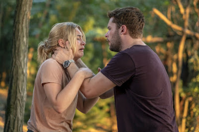 A24's 2019 Midsommar movie review and movie still where Jack Reynor comforts a crying Florence Pugh in a forest