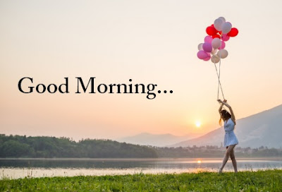 woman with balloon walking near lake in the morning sun rise