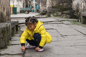 Petite fille chinoise s'amusant dans une ruelle de Xidi