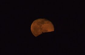 orange moon rising over house