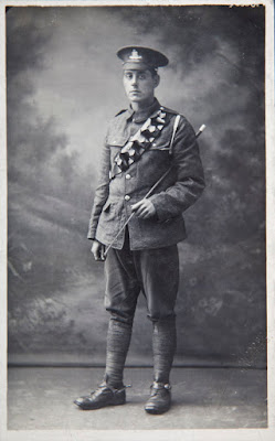 A black and white photo of a soldier in the Royal Artillery wearing a bandolier and carrying a cane