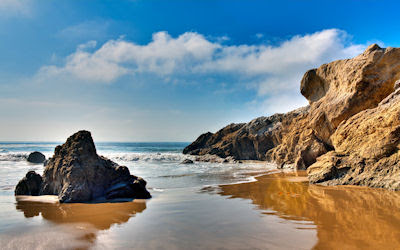 Hermosa playa con arenas blancas y rocas marrón