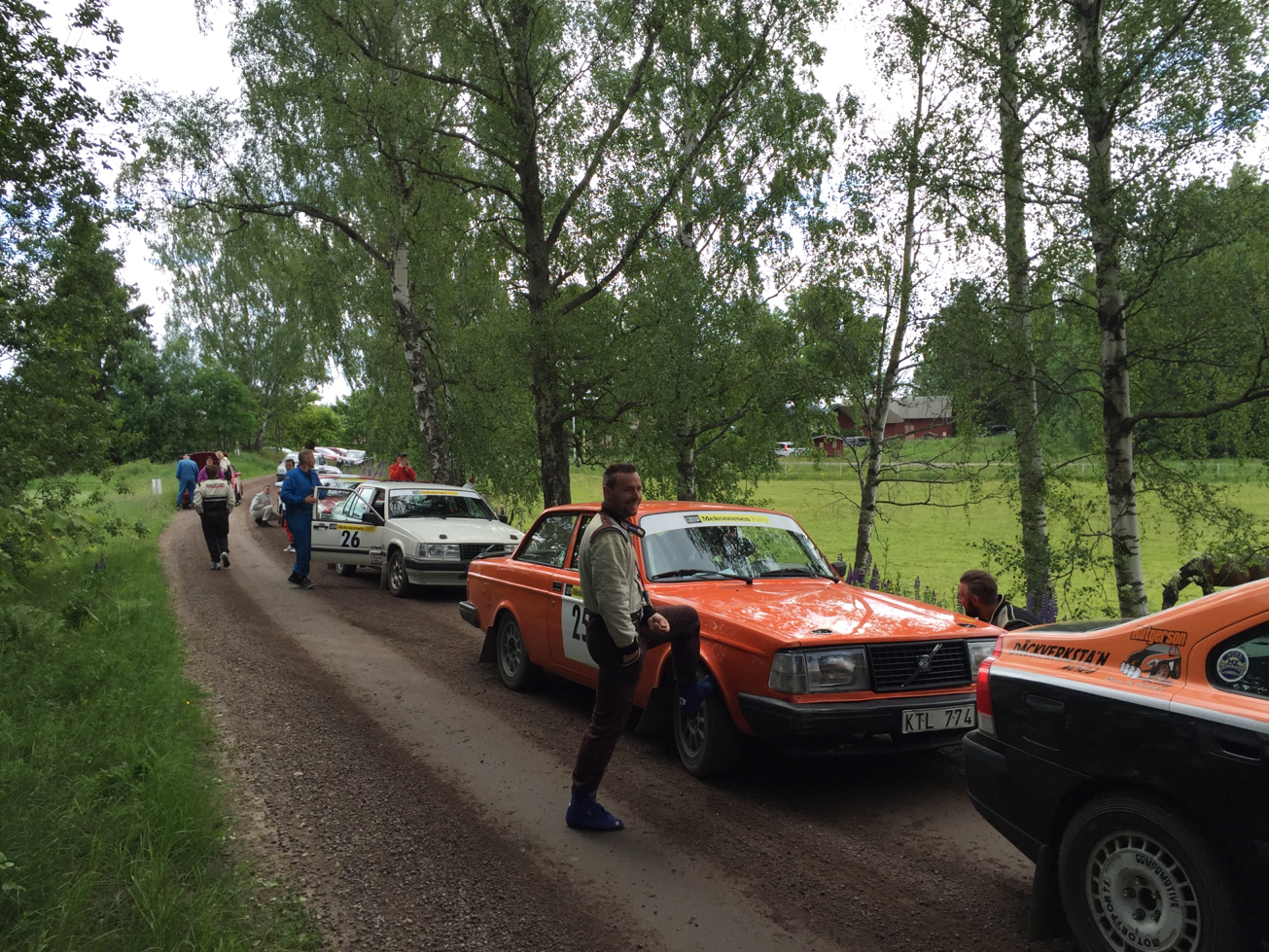 Stämningsbild från TK-kön inför SS2. Fredrik Menck syns leende stoppa upp huvudet vid skärmen och i blått ses Björn Kallin undra var hans co-driver tagit vägen.