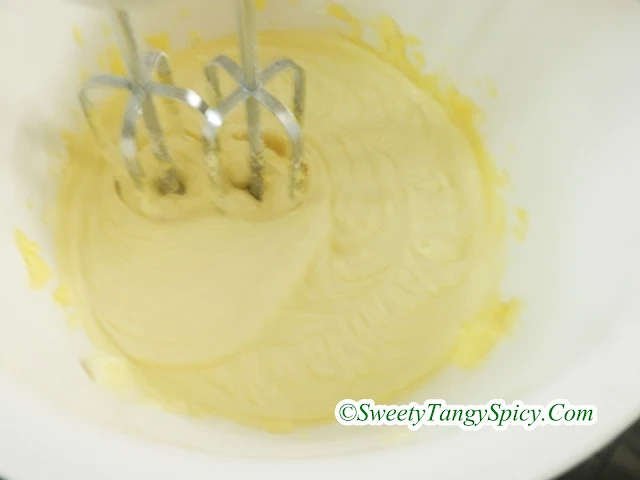 Whipped egg and sugar mixture in a mixing bowl, pale yellow, thick, and creamy.