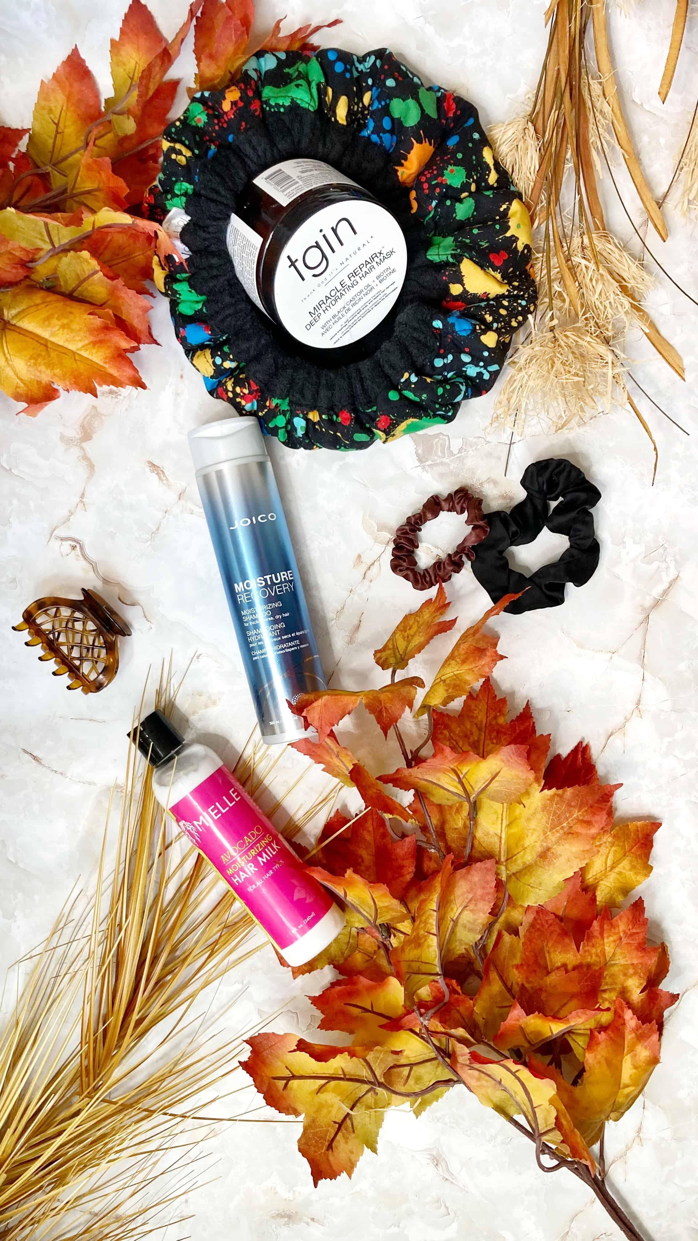 three hair products sitting on a fall themed background.