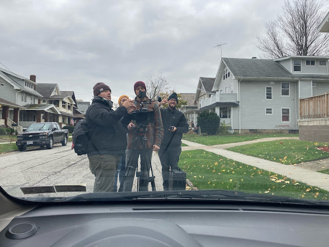 A film crew viewed through a car windshield