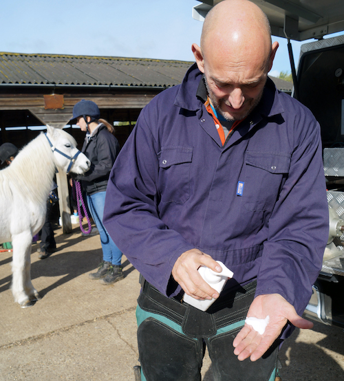 farrier demonstrates hand cleaning biosecurity