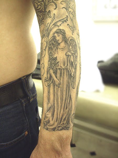 A recently finished custom design religious sleeve tattoo in black and grey