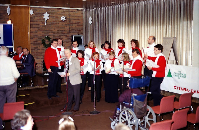 Gord Atkinson introduces the Stairwell Carollers on the Christmas Exchange broadcast