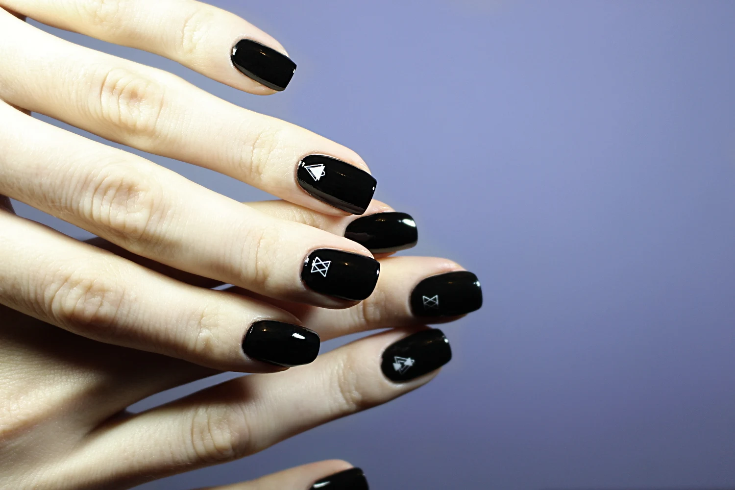 a close-up of a basic black nails looks with glossy finish on a short, natural nails