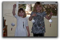 two children hold mobiles they made in church school