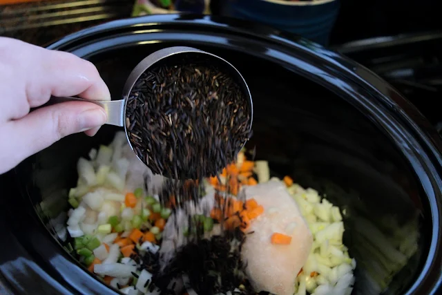 The black rice being poured into the crock pot.