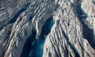 In this July 19, 2011 photo, pools of melted ice form atop Jakobshavn Glacier, near the edge of the vast Greenland ice sheet. (Photograph Credit: Brennan Linsley/AP) Click to Enlarge.