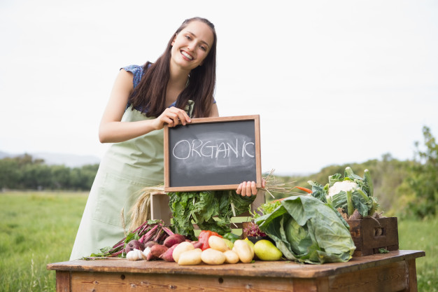 Mulher em uma barraca vendendo alimentos organicos