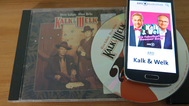 Links liegt eine Doppel-CD von Oliver Kalkofe und Oliver Welke, rechts läuft der neue Podcast von 'KalK und Welk' als Free Stream auf dem Smartphone