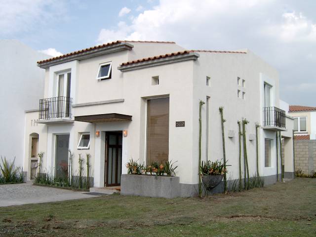 Fachada de residencia moderna con balcon lateral