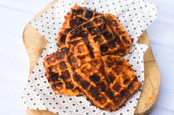 Tofu grilled in a waffle maker on a wooden board