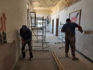 All three men scraping the walls