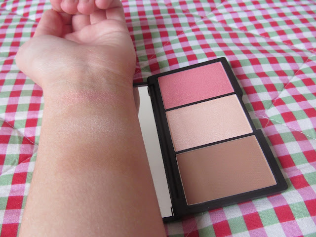 Forearm with light brown contour, shimmery cream highlight and rose gold blush powders swatched 