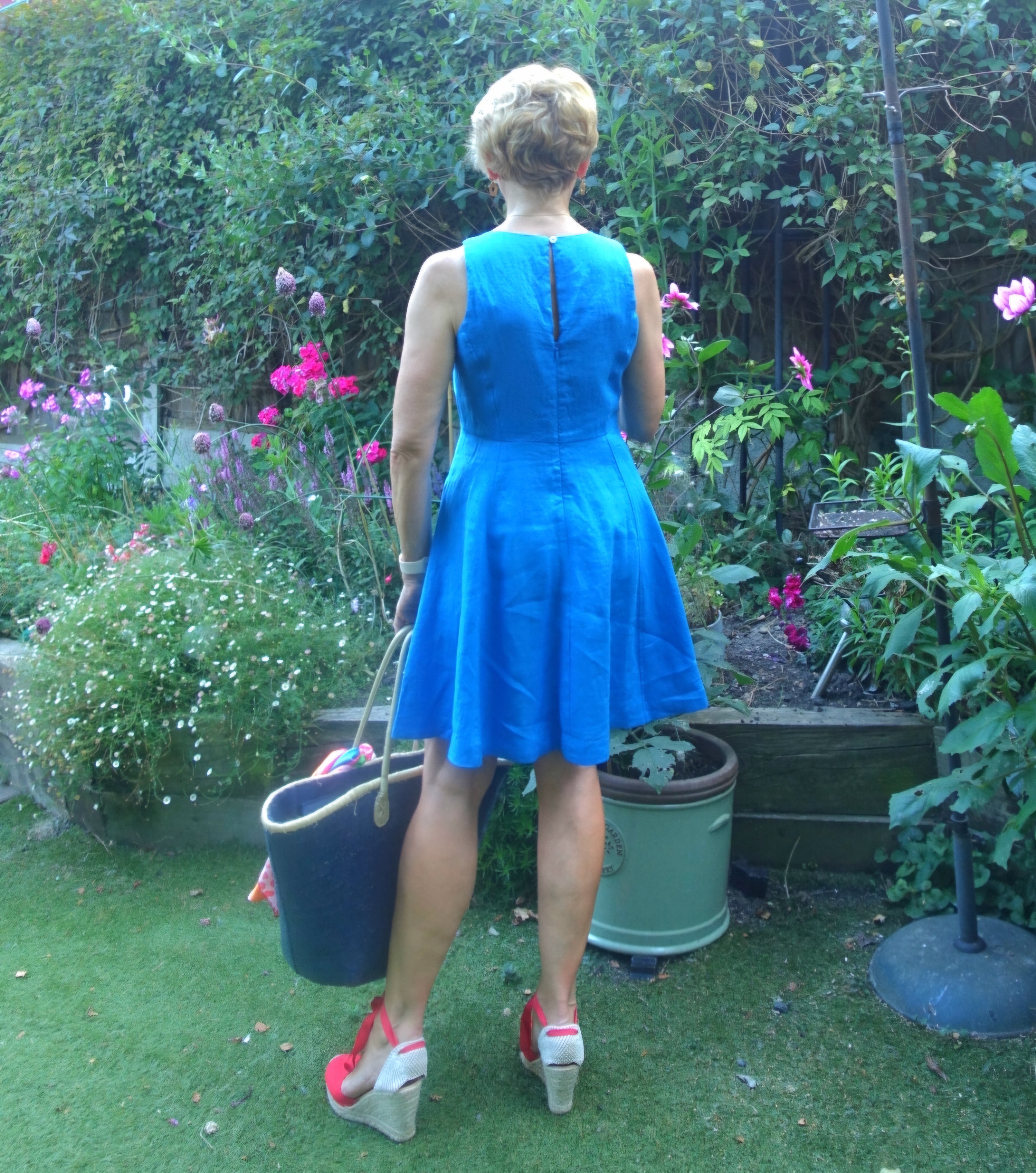 Cute blue linen dress worn by Is This Mutton with red espadrilles and a blue sequin tote bag