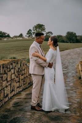 bride and groom on stone bridge holding each other