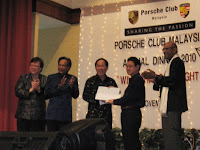 The main individuals of Porsche club giving out a momento