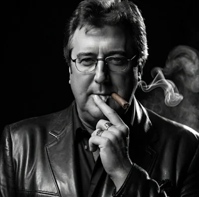 Black and white photographs of country starving scale wearing black leather blazer and smoking a cigar