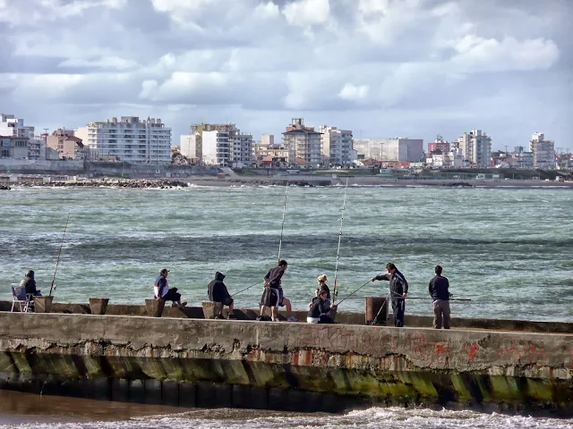 Pescadores en escollera ,al fondo Mar Del Plata