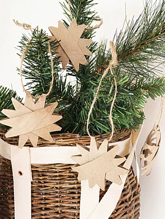 cardboard ornaments on greens in basket