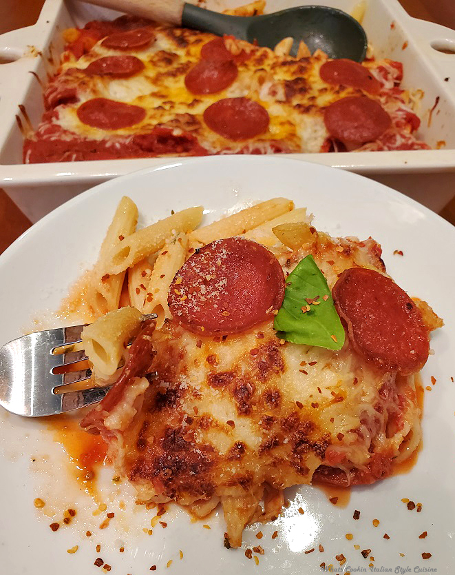 this is a dish of pepperoni pasta on a white plate and a casserole of the rest of it in the background