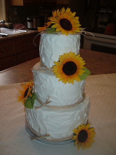 Three tier round white wedding cake with edible pearls small white roses and