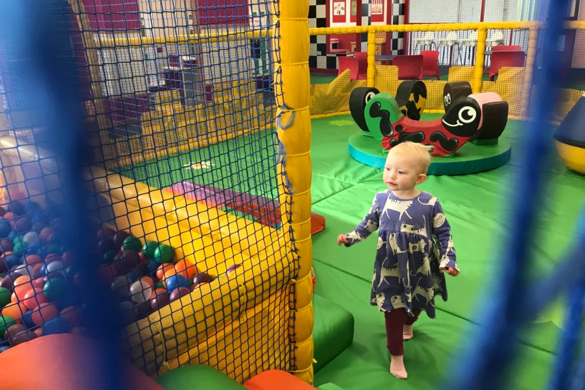 A toddler at a soft play centre in Essex looking at a ball pool