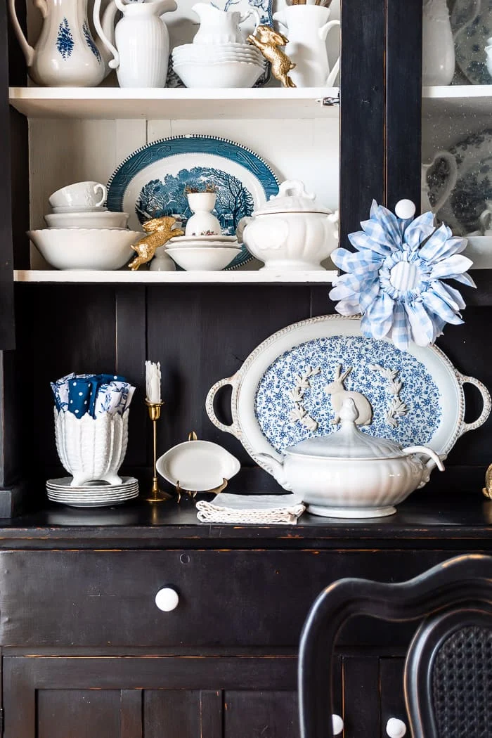 blue and white dishes, china cabinet, gold bunnies, blue checked flower