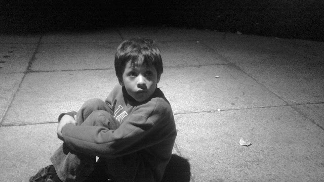 foto de niño triste y solo en la calle (oscuridad) con cara de abandonado