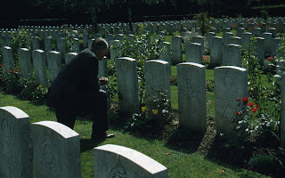 Charles kneeling in front of his father's grave (Charles Manclark) at Ypres, Belgium Dozingham (Cemetery)  - Photo taken on 1958 trip