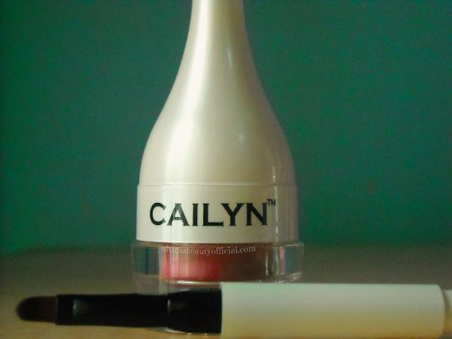 Cailyn lip balm with cover attached and brush in front of jar