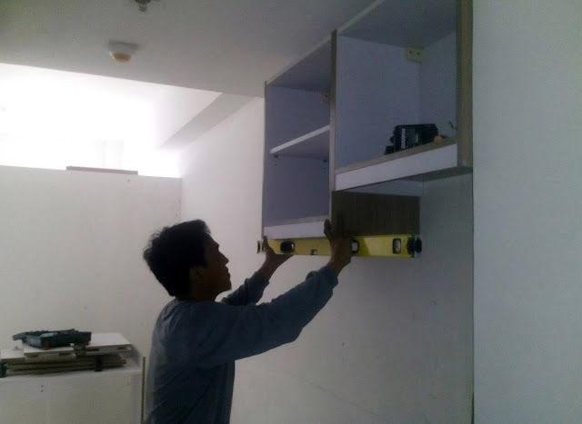 Checking the level of the bottom part of the overhead cabinet
