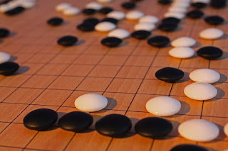 What's the objective of a grandmaster in a game of Go?