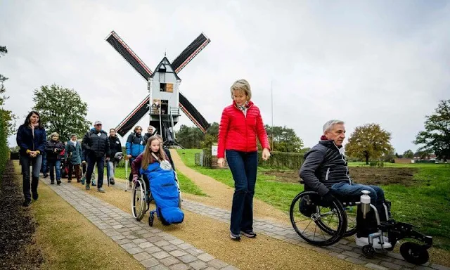 Queen Mathilde wore a red puffer jacket and she wore navy denim jeans pants. Crown Princess Elisabeth