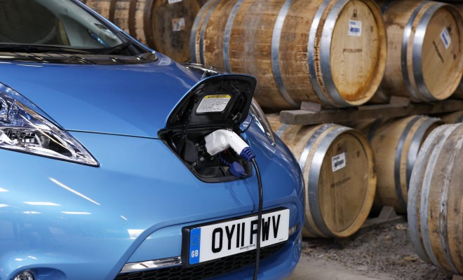 Nissan Leaf charging next to Scotch whisky barrels