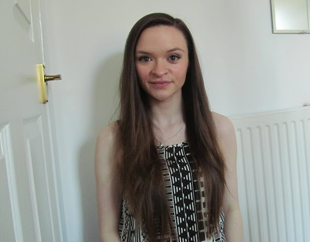 girl with long brown straight hair wearing black and white sleeveless aztec print top