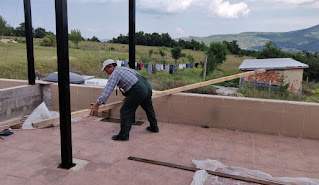 Bekir hefts wood onto the balcony