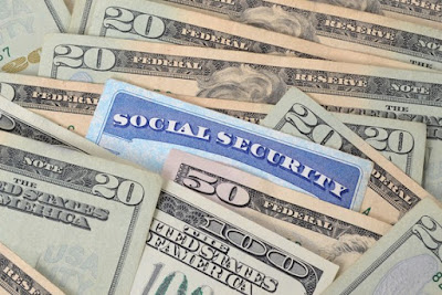 Photo of a Social Security card nestled in paper money