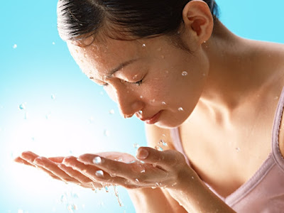 Chica refrescándose el rostro con agua