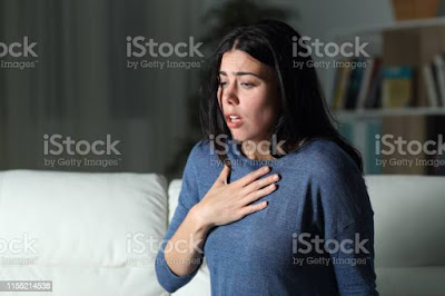 A woman feeling anxious and scared wearing bue top